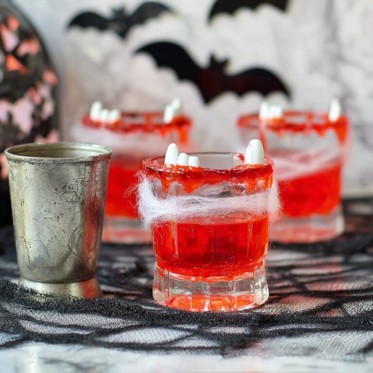 Halloween Punch Recipe with Cranberry, Strawberry Soda, Rum Chata, Lime Sherbet, and Gummy Worm Garnish Recipe